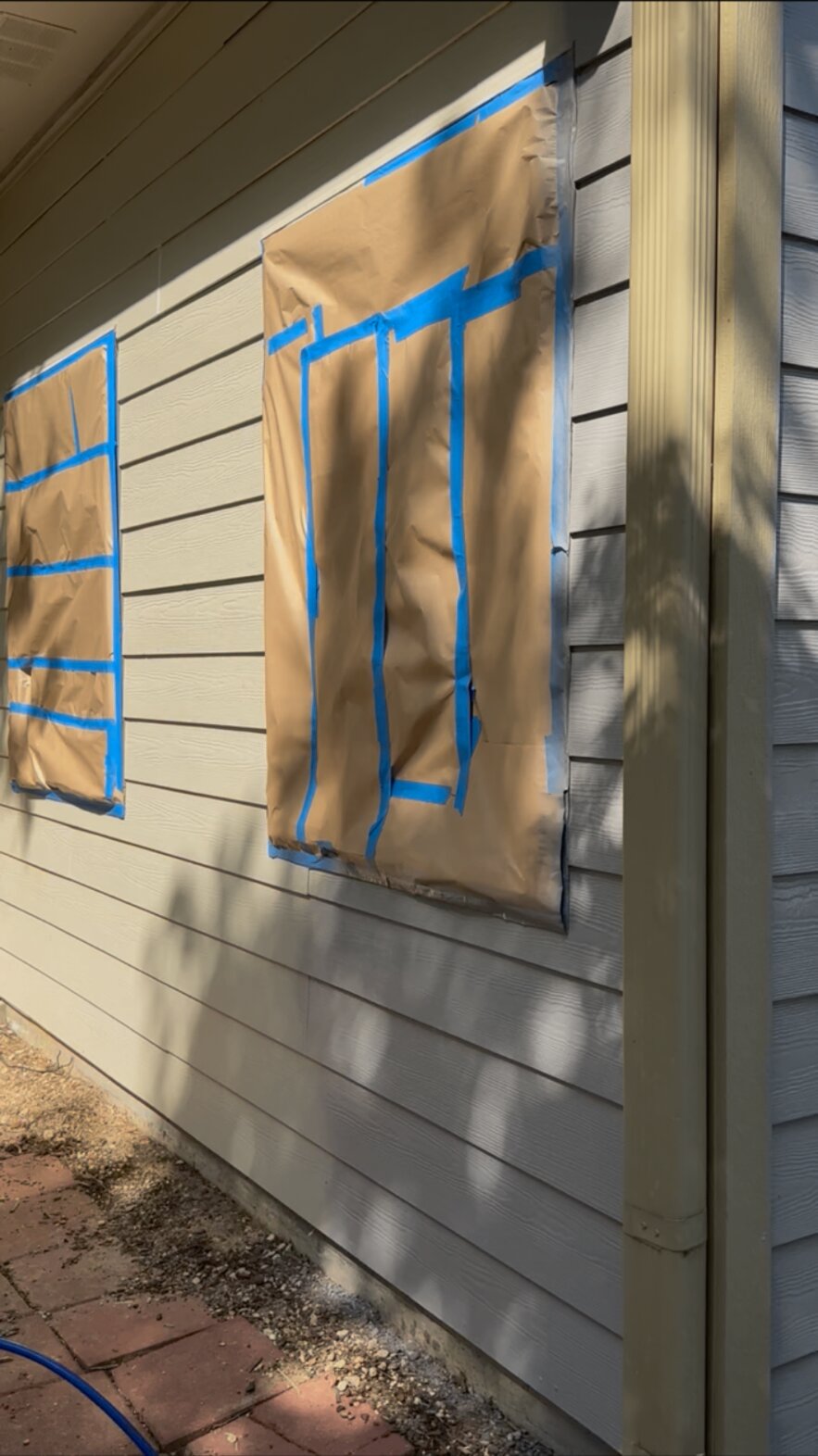 Close-up of windows covered with paper and blue tape before painting