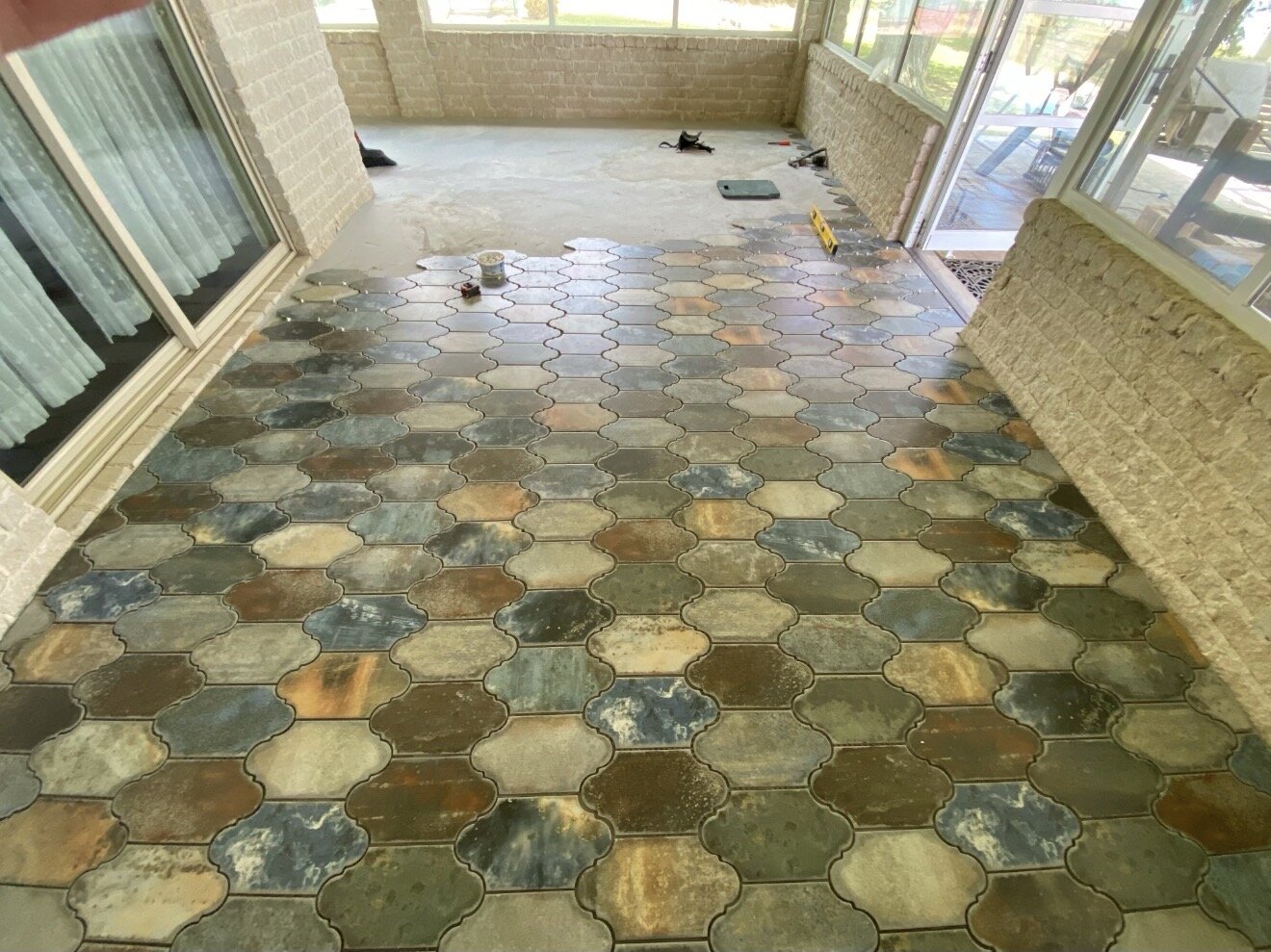 Decorative interlocking paver flooring across an enclosed patio