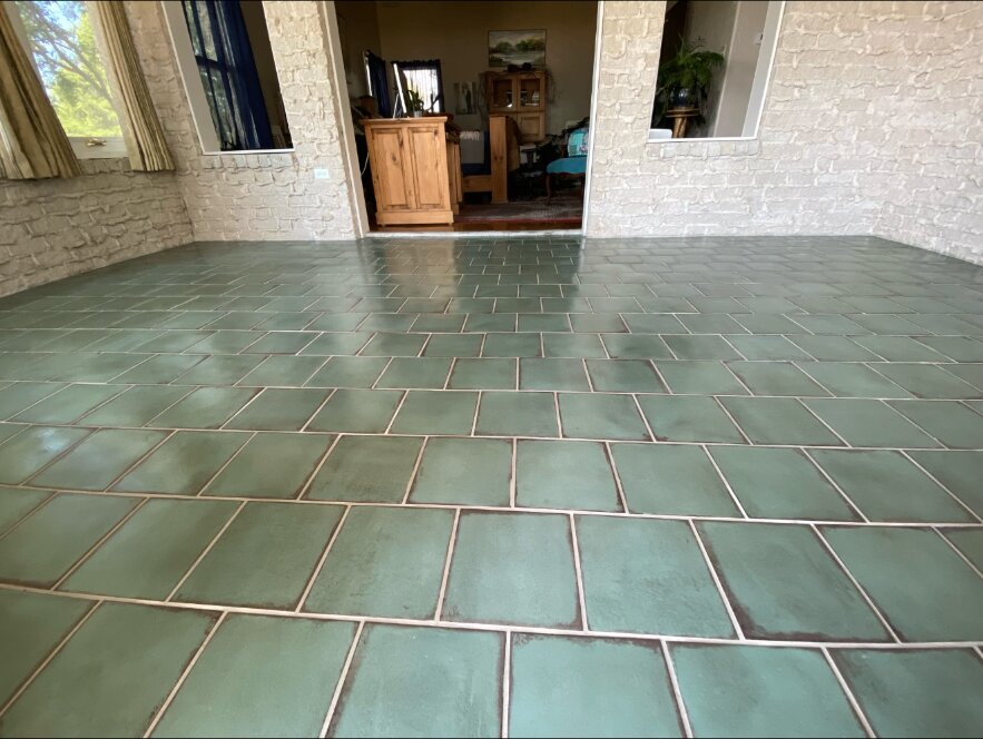 Finished green tile flooring in an enclosed patio