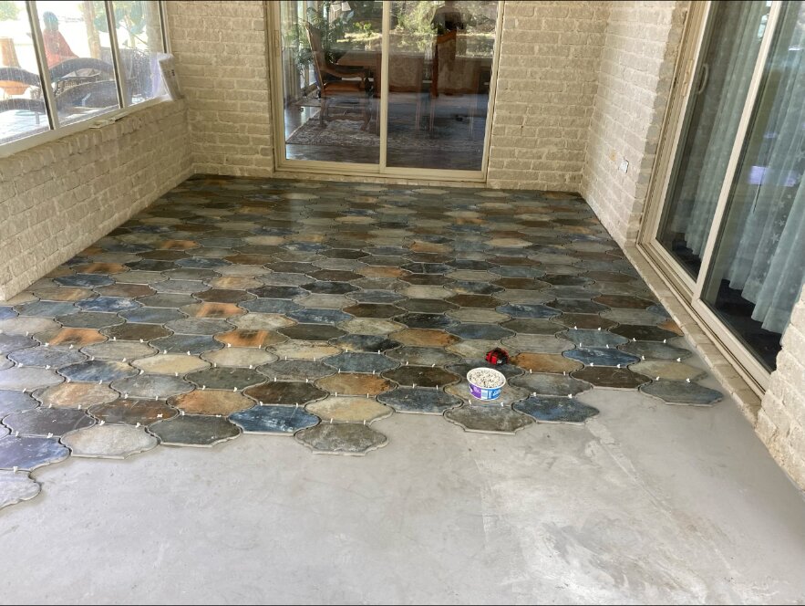 Wide view of the enclosed patio with paver installation in progress